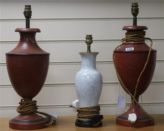 A pair of red and black toleware lamps and another 49cm, 37cm